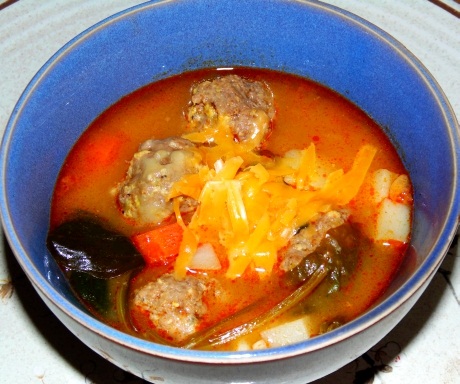 Meatball soup with cheddar cheese and spinach